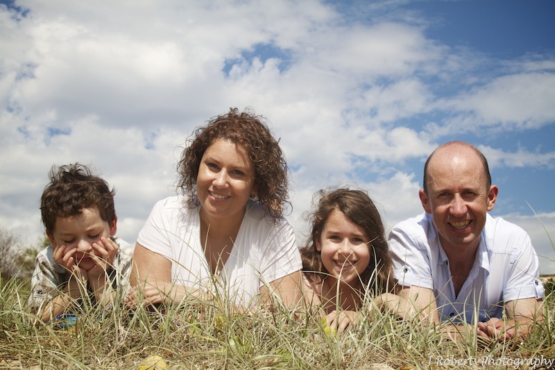 Family lying in the dunes at beach - family portrait photography